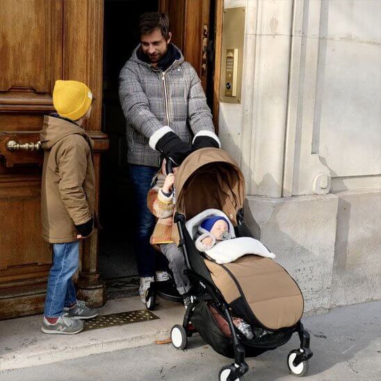 Chanceliere poussette dans une promenade hivernale avec un bébé, assurant confort et protection.