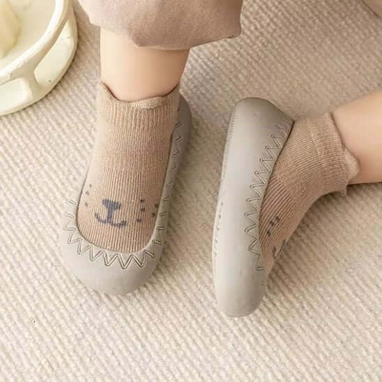 Chaussure bebe de couleur grise avec chaussettes beiges, conçues pour le confort des premiers pas.
