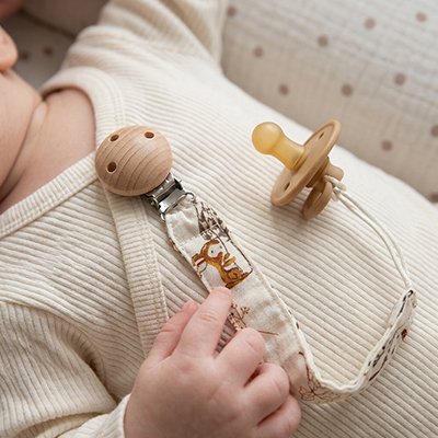 Attache tetine élégante portée par un bébé dans son transat