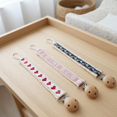 Attache tetine pratique fixée sur la tenue d'un bébé confortable