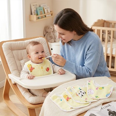 Mère donnant à manger à un bébé en utilisant un bavoir bébé coton ultra-absorbant et coloré.
