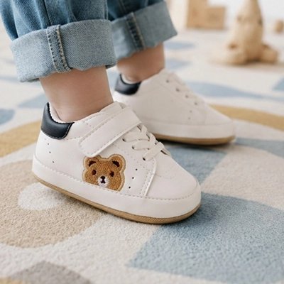Chaussure bebe blanche avec un ourson, idéale pour les premiers pas de votre enfant.