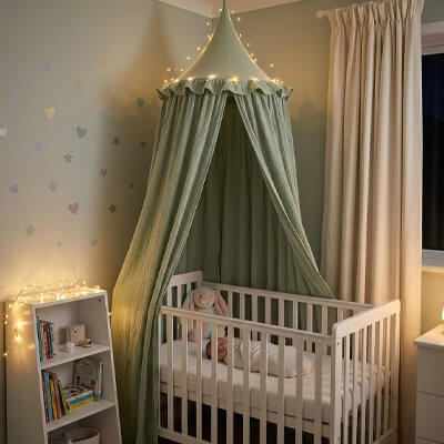 Ciel de lit bébé féerique installé au-dessus d'un berceau, créant une ambiance magique dans la chambre d'enfant.