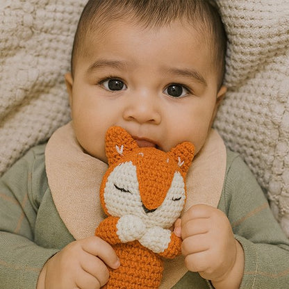 Doudou bebe tenant un doudou en forme de renard, jouet doux pour réconfort et câlins.
