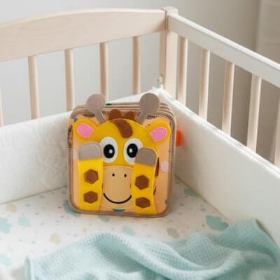 Livre en tissu bébé représentant une girafe, idéal pour l'éveil sensoriel des tout-petits.