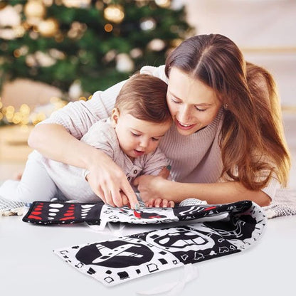 Maman et bébé s'amusent avec un livre en tissu bébé, stimulant l'éveil des sens à travers des images contrastées.