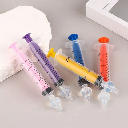 Mouche bebe, seringues colorées adaptées aux soins de bébé, facilitant l'administration de médicaments en douceur.