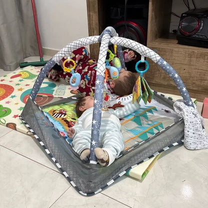 Tapis d'éveil bébé Color Baby avec deux nourrissons jouant sous un arche d'activités colorée.