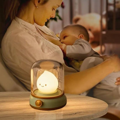 Veilleuse bébé en forme de chandelle sur une table avec mère allaitant son bébé dans une chambre accueillante.