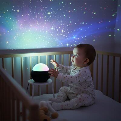 Un bébé explore une veilleuse projection bebe qui projette des étoiles colorées sur le mur.